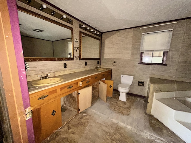 full bath featuring double vanity, a textured ceiling, a sink, and toilet