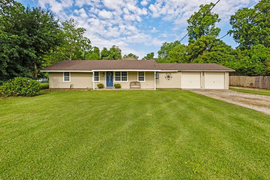 350 Holly St, Bridge City, TX 77611 - ranch-style house featuring dirt driveway, an attached garage, and covered porch