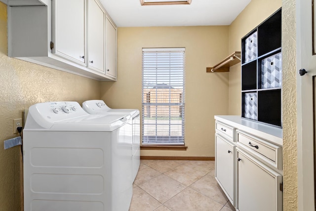 laundry area featuring separate washer and dryer, light tile patterned floors, and cabinets