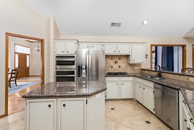 kitchen featuring white cabinetry, sink, lofted ceiling, and stainless steel appliances