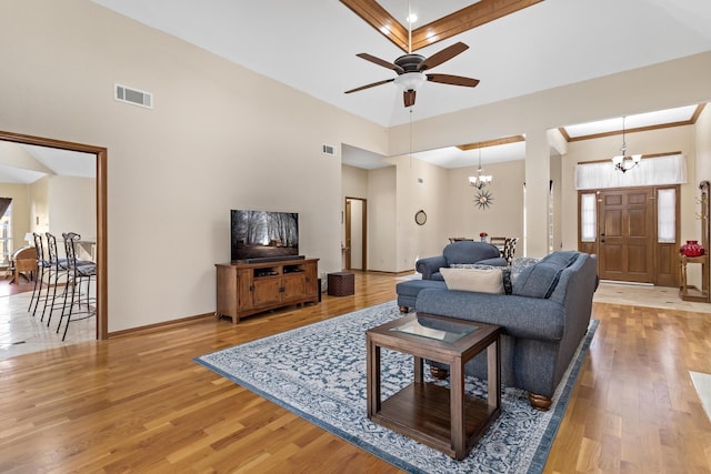 living room with light hardwood / wood-style flooring and ceiling fan with notable chandelier