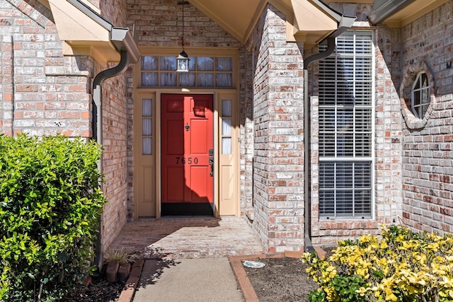 view of exterior entry with brick siding