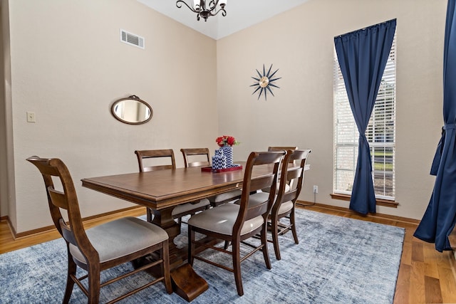 dining area with a chandelier and wood-type flooring