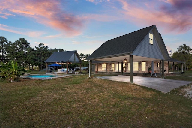 back house at dusk featuring a yard