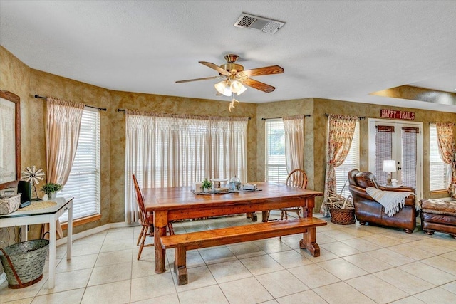 dining area featuring light tile patterned floors, a textured ceiling, and ceiling fan