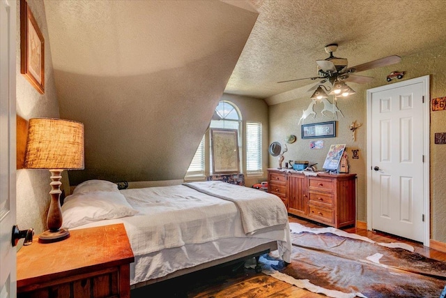 bedroom featuring a textured ceiling, light hardwood / wood-style floors, ceiling fan, and lofted ceiling