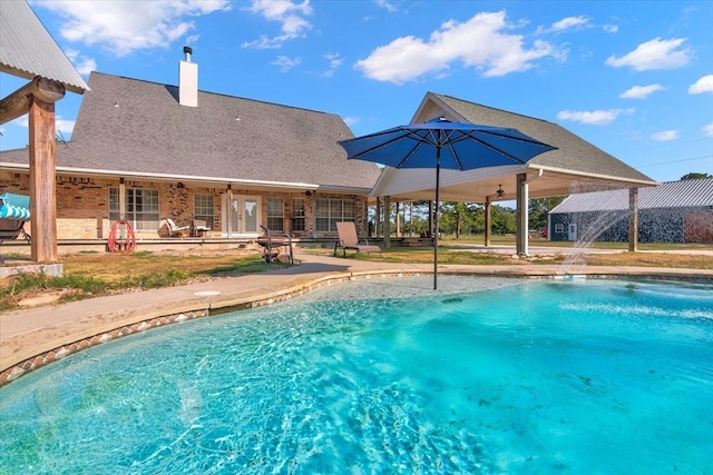 view of pool with pool water feature, ceiling fan, and a patio