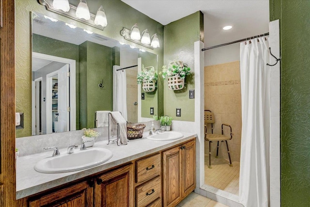 bathroom with tile patterned flooring, vanity, and walk in shower