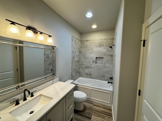 full bathroom featuring vanity, hardwood / wood-style flooring, toilet, and tiled shower / bath