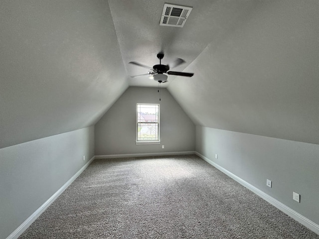 bonus room featuring carpet flooring, a textured ceiling, ceiling fan, and lofted ceiling