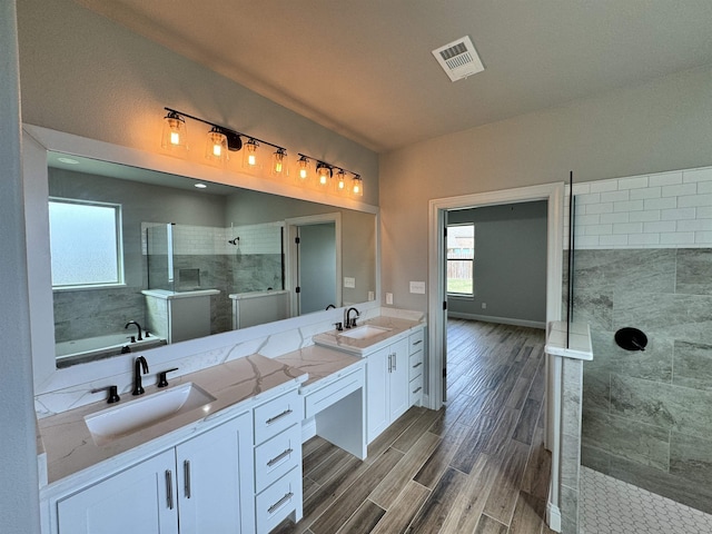 bathroom with vanity and shower with separate bathtub