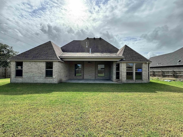 rear view of house with a yard and a patio