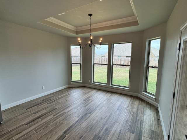 unfurnished dining area with a notable chandelier, a raised ceiling, and crown molding