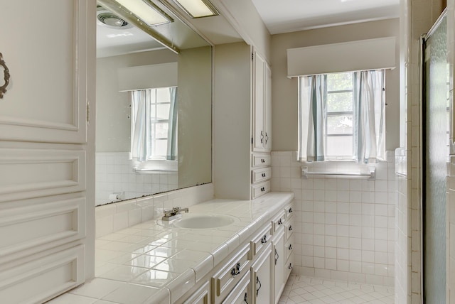 bathroom featuring tile patterned flooring, vanity, and tile walls