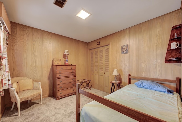 carpeted bedroom with wooden walls and a closet