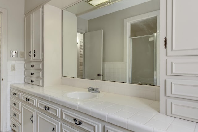 bathroom with vanity and a shower with shower door