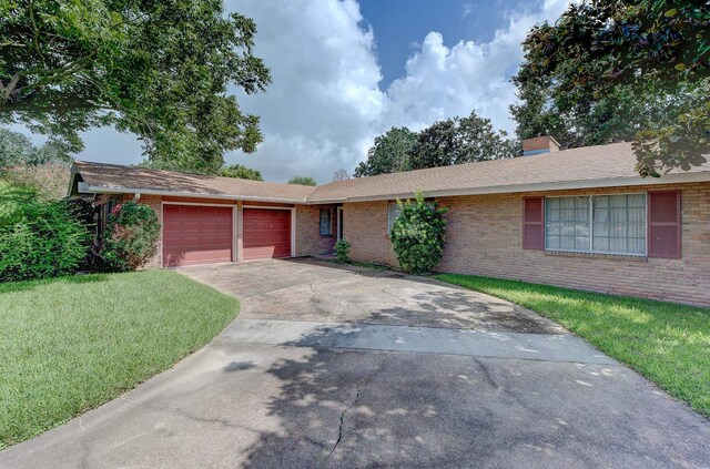 single story home with a garage and a front lawn