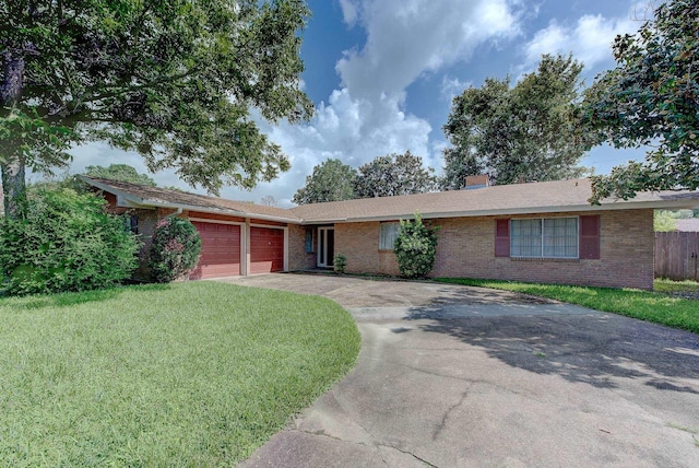 ranch-style house featuring a garage and a front lawn