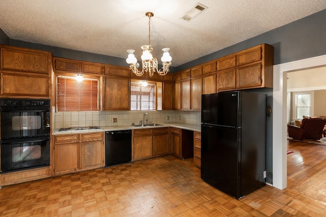 kitchen with tasteful backsplash, sink, pendant lighting, and black appliances