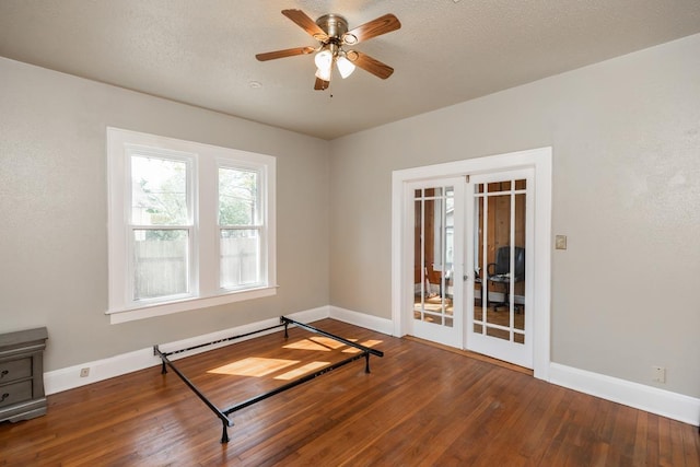 interior space featuring a baseboard radiator, hardwood / wood-style flooring, ceiling fan, a textured ceiling, and french doors