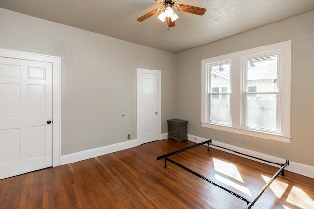 empty room featuring ceiling fan, wood-type flooring, and a textured ceiling