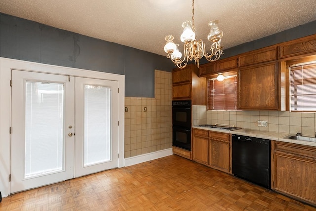 kitchen featuring decorative light fixtures, black appliances, french doors, and a textured ceiling