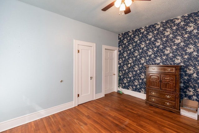 unfurnished bedroom with ceiling fan, dark hardwood / wood-style flooring, and a textured ceiling