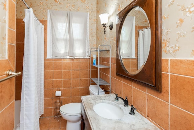 bathroom featuring vanity, tile walls, and toilet