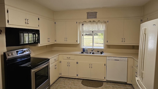 kitchen featuring white cabinetry, sink, light tile patterned flooring, and white appliances