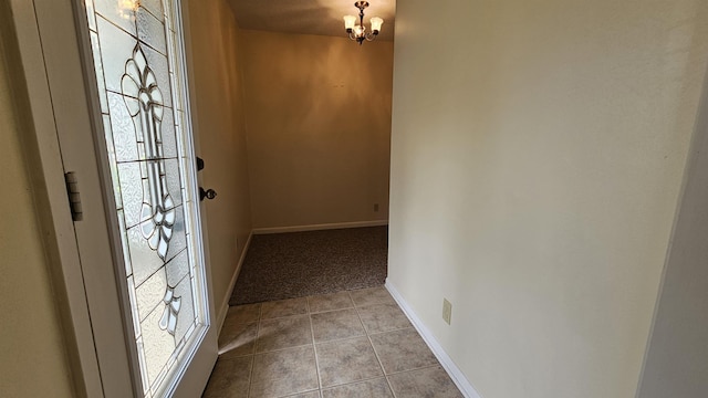 entryway with a notable chandelier and light tile patterned floors