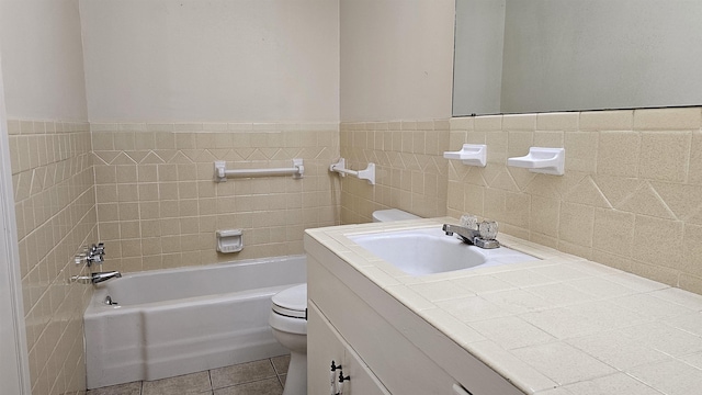 bathroom featuring a bath, tile patterned floors, toilet, vanity, and tile walls