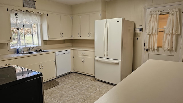 kitchen featuring white cabinets, light tile patterned floors, white appliances, and sink