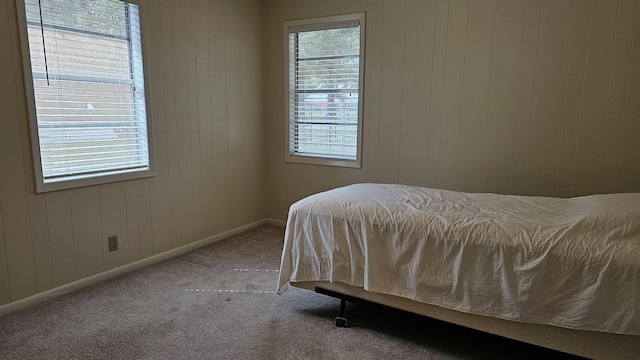 bedroom featuring carpet and wooden walls