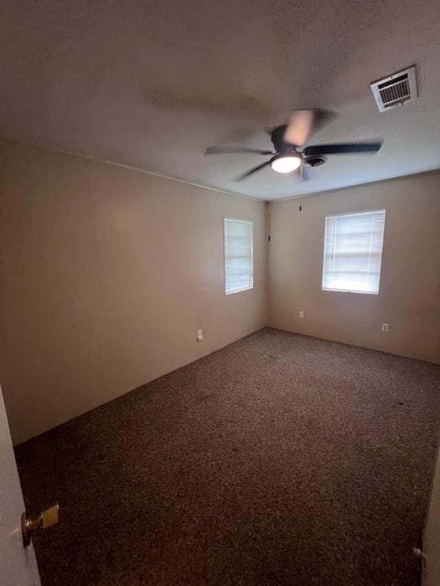 carpeted spare room featuring ceiling fan