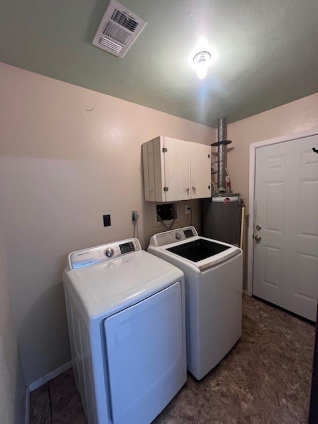 laundry room featuring cabinets, gas water heater, and washing machine and clothes dryer