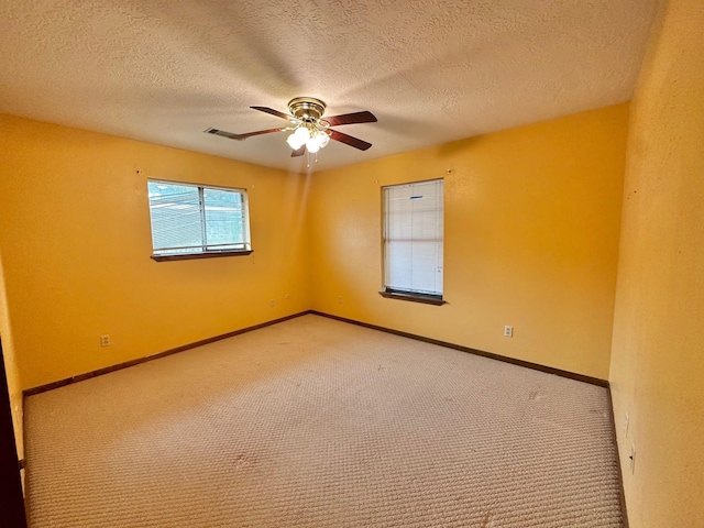 carpeted empty room with ceiling fan and a textured ceiling