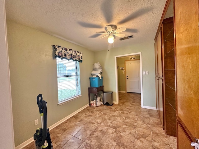 interior space featuring ceiling fan and a textured ceiling