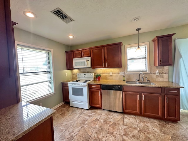 kitchen with sink, backsplash, decorative light fixtures, white appliances, and light tile patterned floors