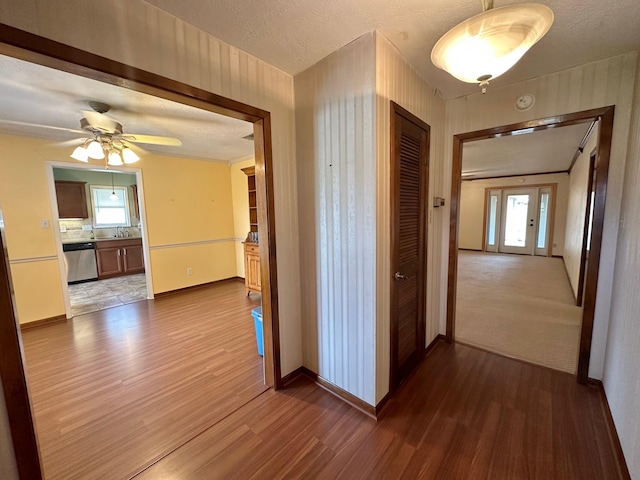 hall featuring wood-type flooring and a textured ceiling