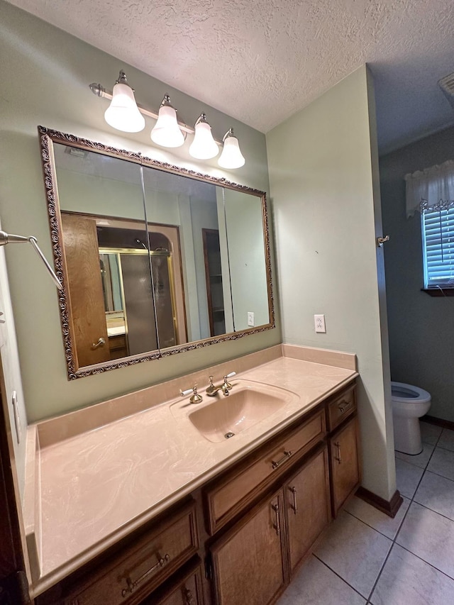 bathroom with vanity, tile patterned floors, toilet, a textured ceiling, and a shower with shower door