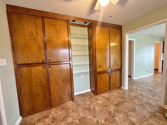 interior space featuring ceiling fan and a textured ceiling