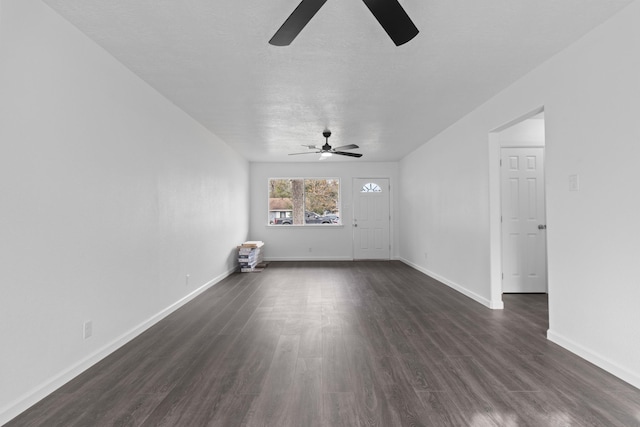 unfurnished living room with a textured ceiling, ceiling fan, and dark wood-type flooring