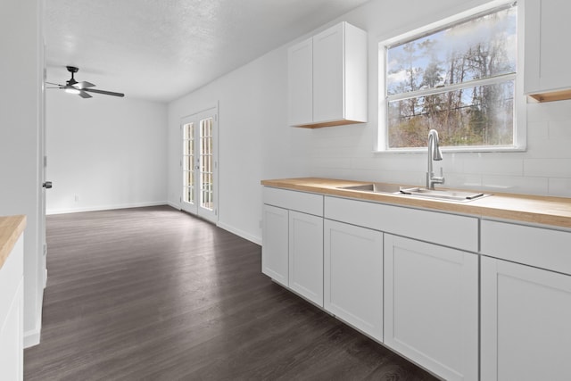 kitchen with white cabinets, ceiling fan, dark hardwood / wood-style floors, sink, and butcher block counters