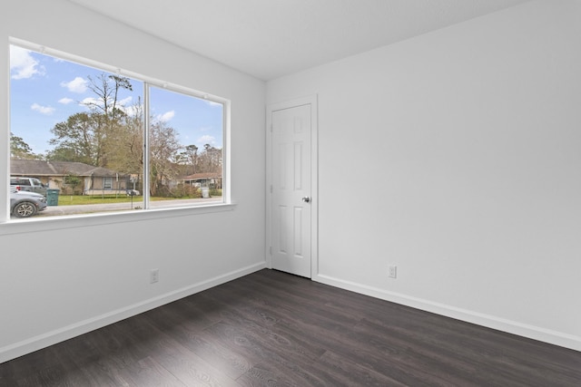 unfurnished room with dark wood-type flooring