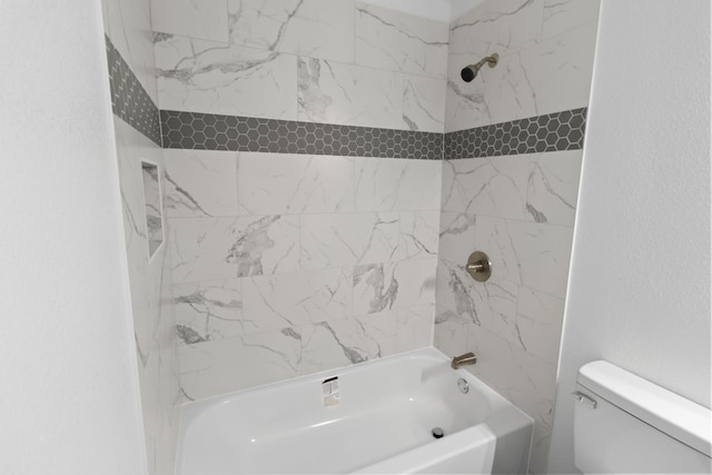 bathroom with tiled shower / bath combo and toilet