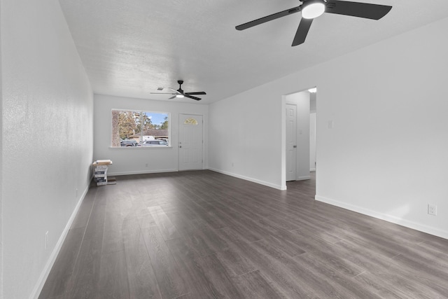 unfurnished living room featuring ceiling fan and dark wood-type flooring