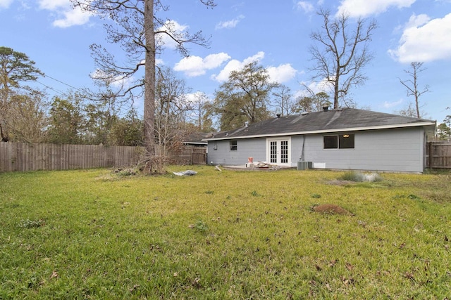 rear view of property featuring a lawn, central AC, and french doors