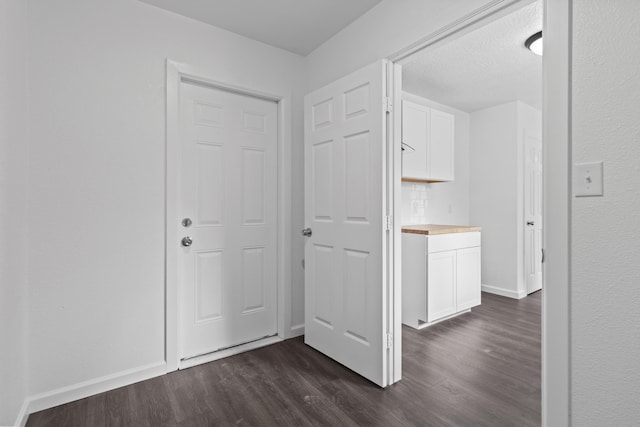 hallway with dark wood-type flooring and a textured ceiling