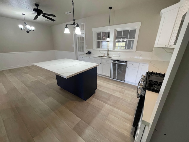 kitchen featuring a center island, gas range, light wood-style flooring, white cabinetry, and stainless steel dishwasher