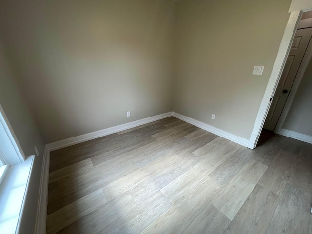 unfurnished room featuring baseboards and light wood finished floors